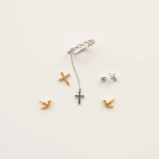 Confirmation cross pendant necklace, stud earrings, and bracelet arranged neatly on a light background