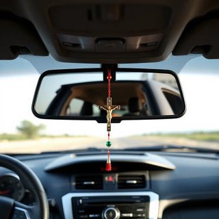 Small rosary with crucifix hanging from a rearview mirror inside a car