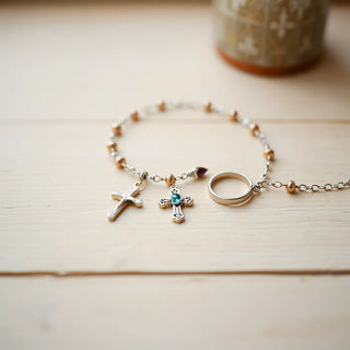 Delicate crucifix and pendant jewelry pieces arranged on a light wooden surface