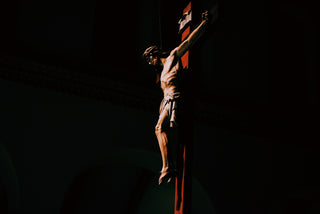 a statue of a man on a cross in the dark