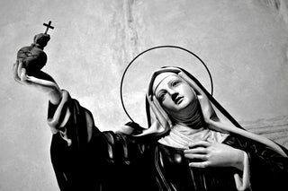 Statue of a saint holding a heart with a cross
