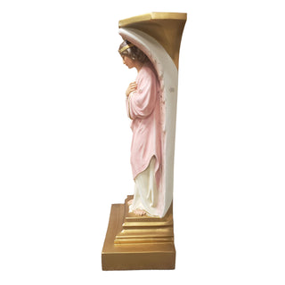 Hand-painted fiberglass resin angel resting beside a tall cross on a pedestal base — alternate view