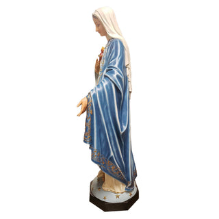 Tall hand-painted statue of the Blessed Mother with one hand outstretched, standing outdoors.